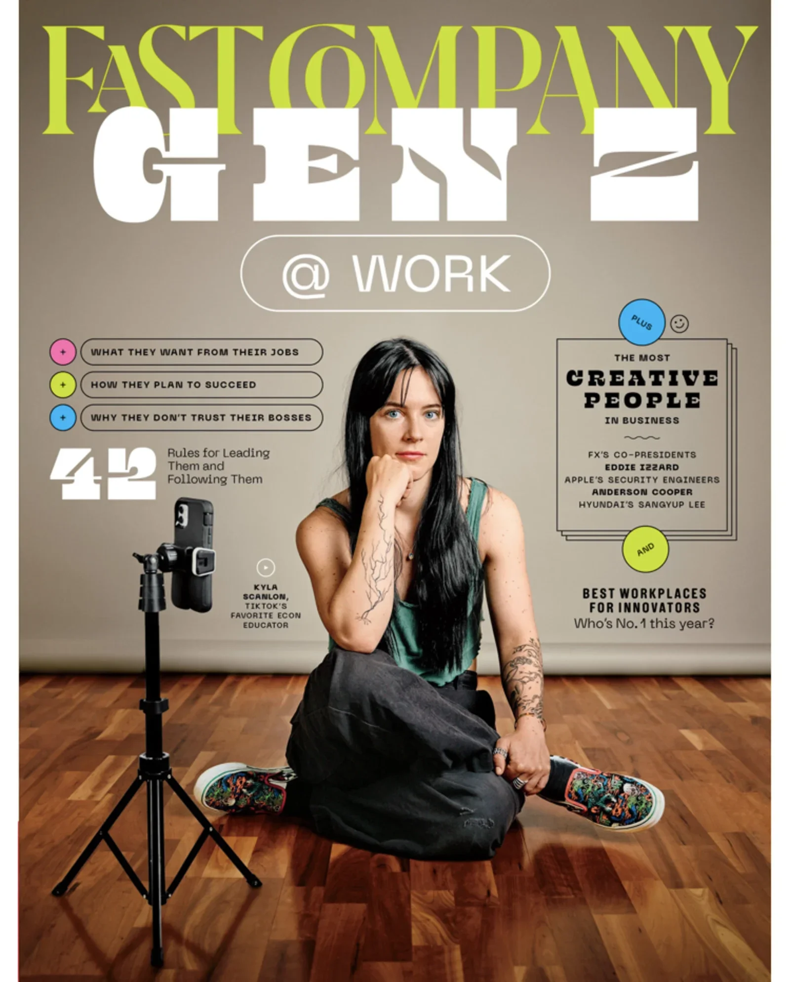 A woman with black hair, sitting on the floor with one leg bent and one hand resting on her chin, in front of a poster about Gen Z at work. The poster contains colorful text and graphics, including headlines about work habits and a list of influential people.
