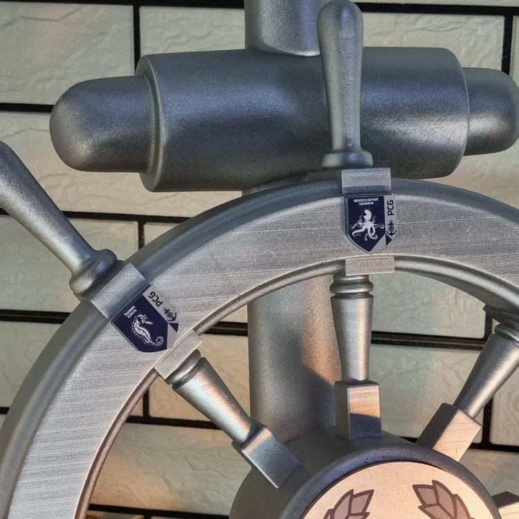 Close-up of a metallic plaque with a lion and shield insignia, attached to a metallic stand or fixture.