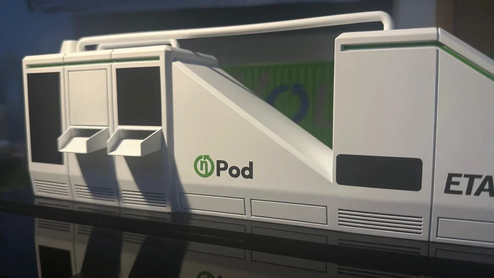 Close-up of a train or tram door with green and black logos, the word 'Pod', and part of the word 'ETA' visible.