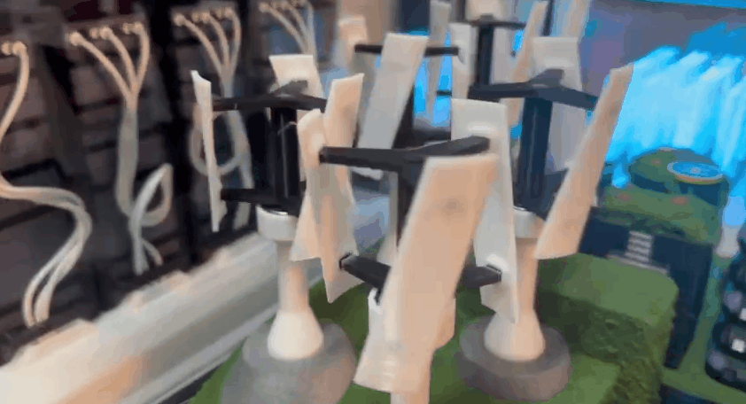 Homemade marble run with wooden and plastic pieces on a green surface.