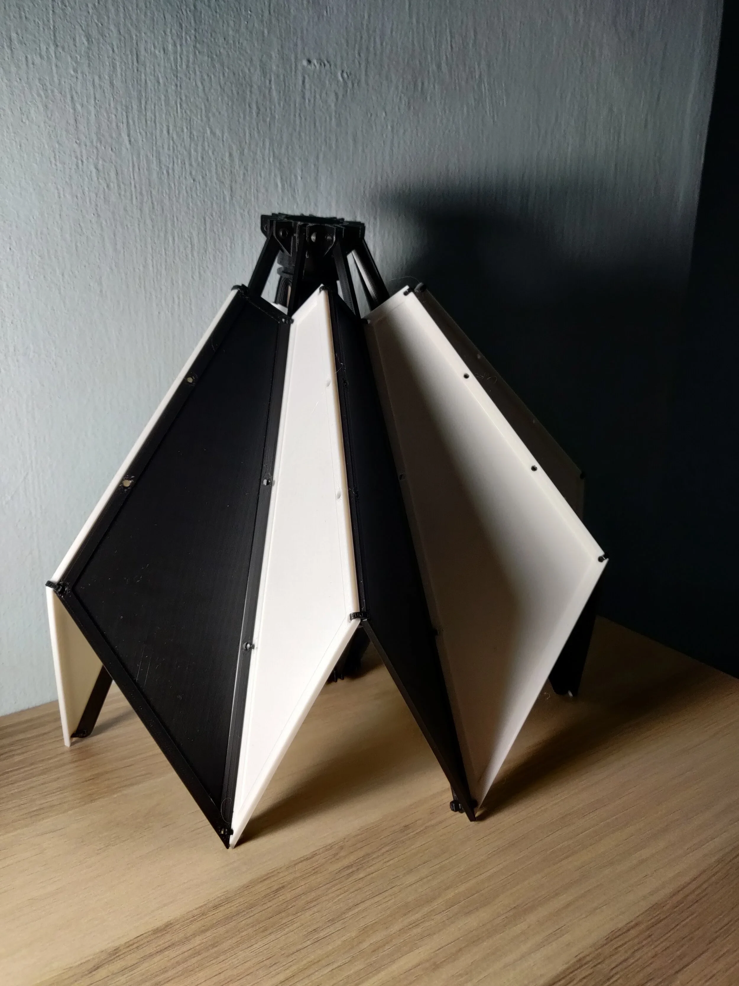 A folded collapsible photo reflector or bounce on a wooden table.
