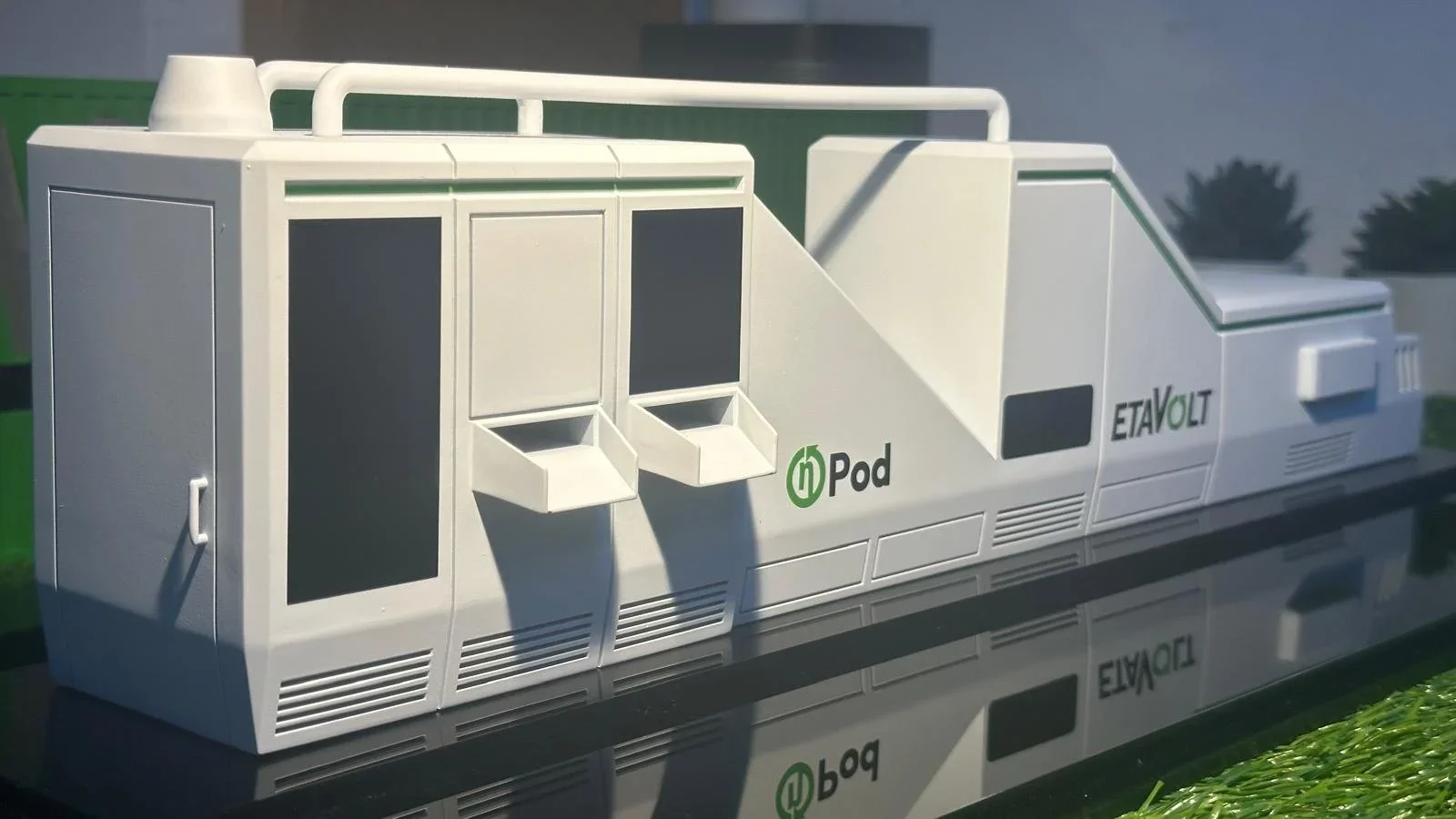 Model of a mobile renewable energy station labeled 'Pod' with logos 'EtAvolt' and 'iPod,' featuring two small dispensers and ventilation grills.