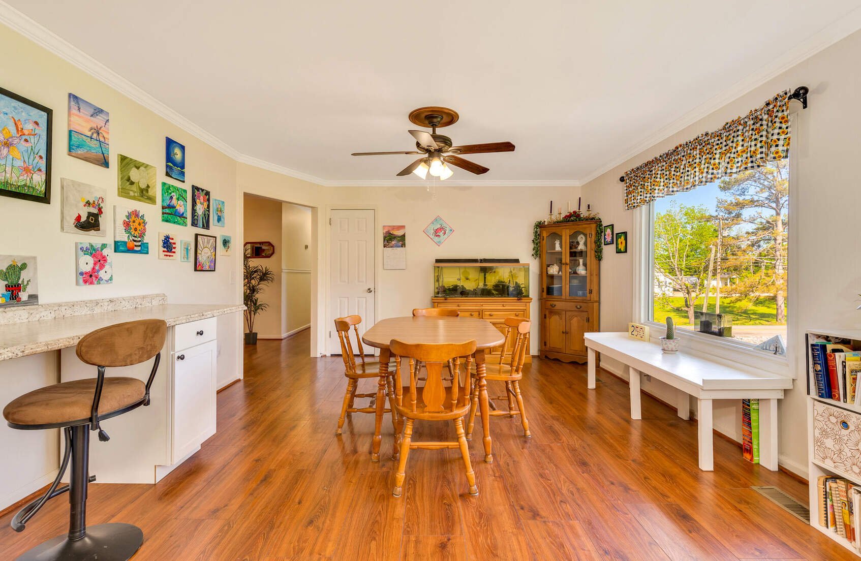 Dining area with hardwood floors and a large front window