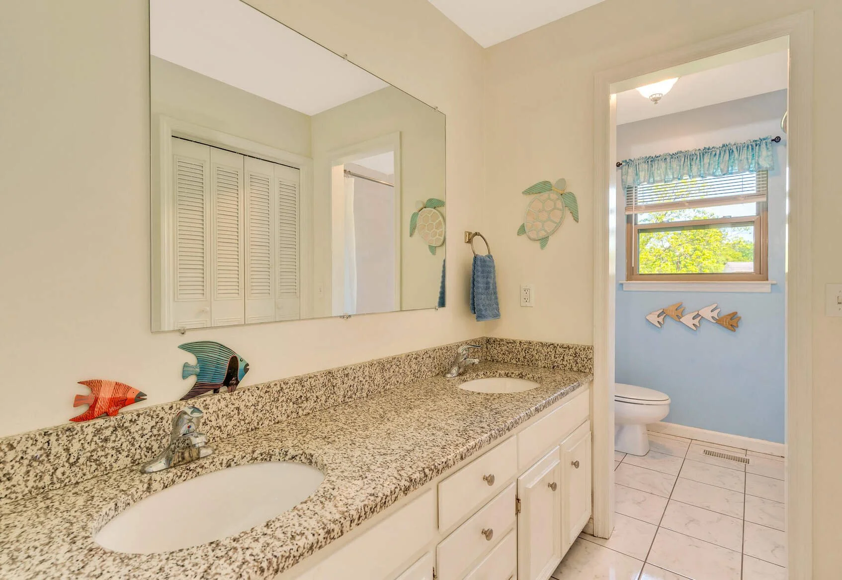 Bathroom with a double granite vanity and separate toilet area