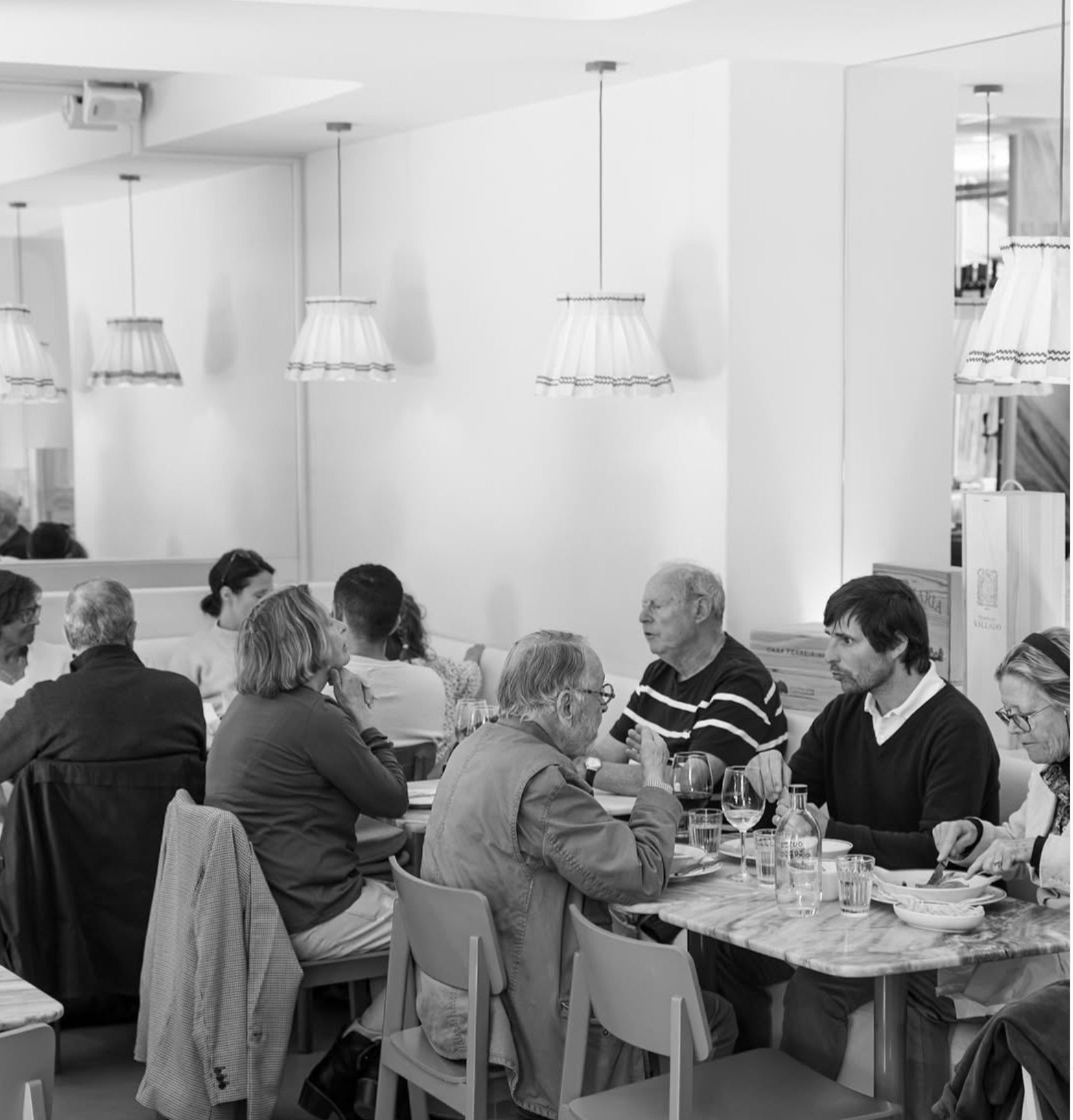 Black and white photo of people eating at Outro Tempo in Lisbon