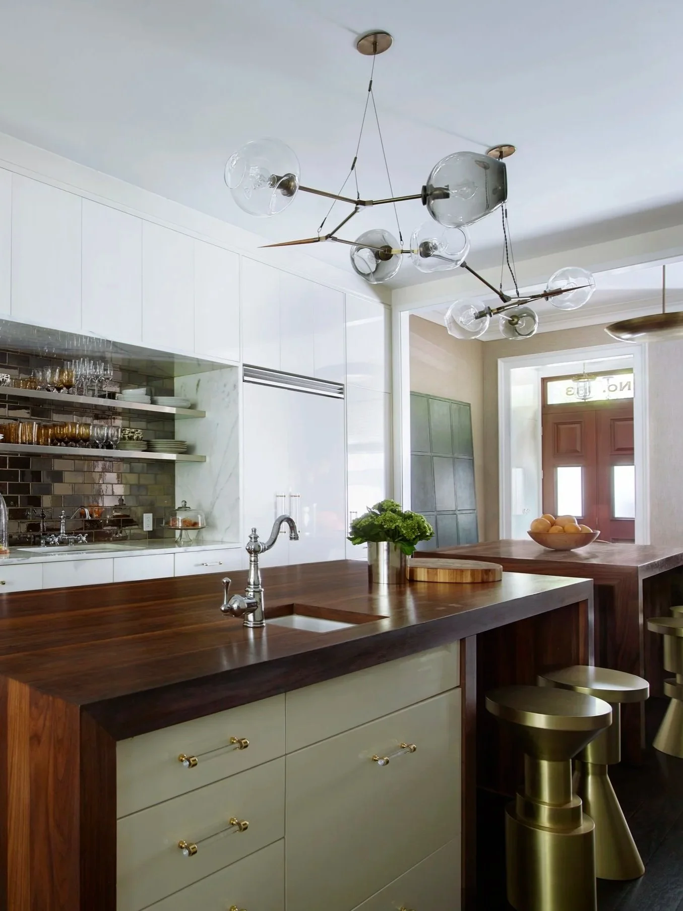 Modern kitchen with glass globe bubble chandelier hanging over the large wood kitchen island