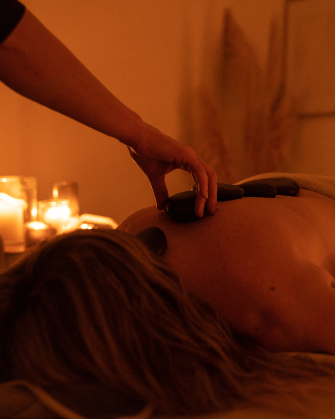 Close-up of a person's hands performing a massage on another person's back.
