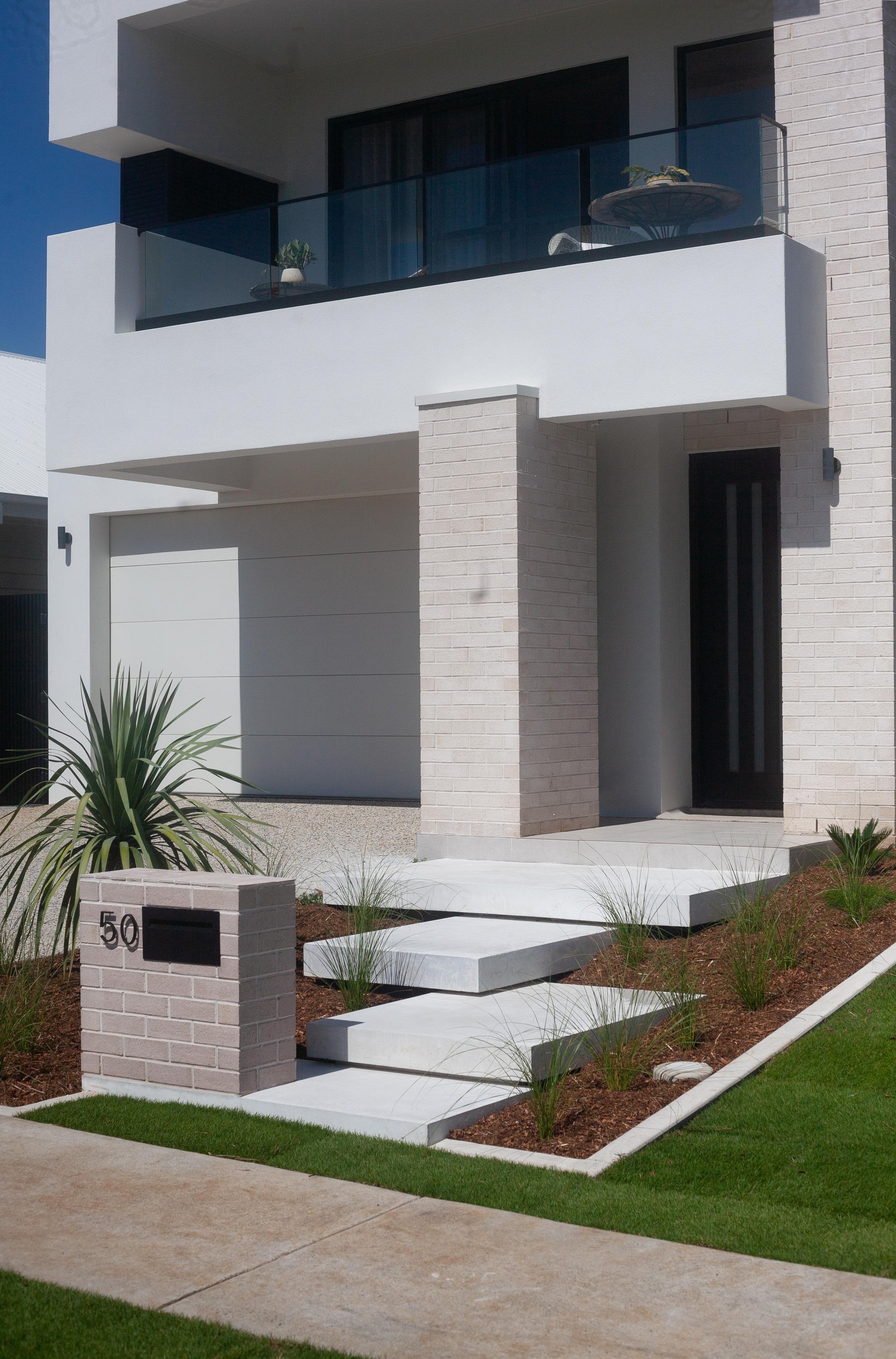 Floating concrete steps leading to the entrance of a house.