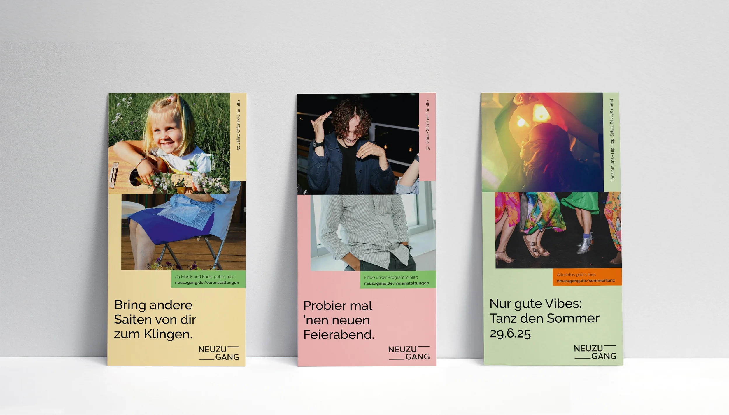 Three colored flyers, each with two photos of people (one showing the upper body and one showing the lower body) and text, are leaning against a gray wall.