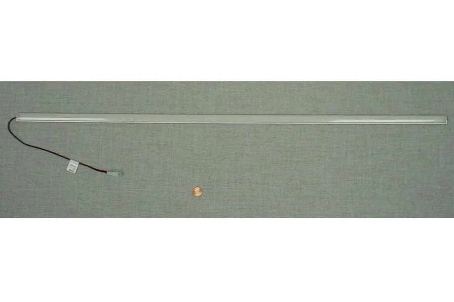 Long LED light strip with a power cord and a penny placed on a gray surface.