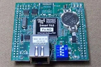 A green circuit board with various electronic components, including a coin cell battery, an Ethernet port, a blue potentiometer, and several chips and connectors.