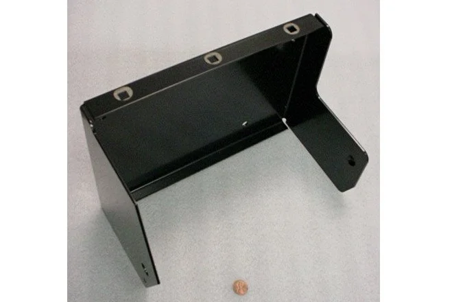 A black metal stand with a hinge, positioned on a light gray surface, with a small penny coin nearby for scale.