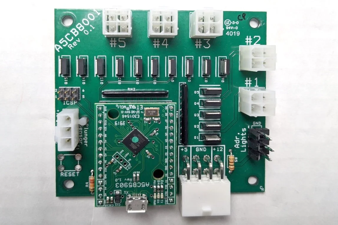 A green circuit board with various connectors, black electronic components, and a smaller mounted microcontroller.