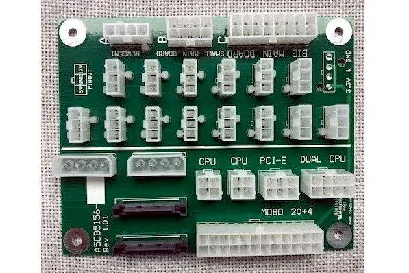 A green printed circuit board with multiple white and black connectors, labeled for CPU, PCI-E, DUAL CPU, and other components, used for electronics or computer hardware assembly.