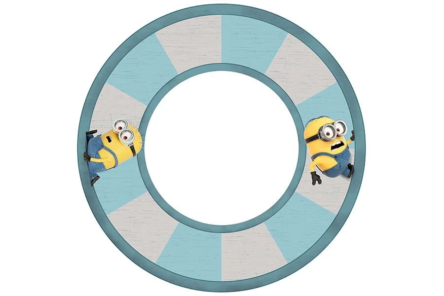 Two minions lying on a circular, segmented game wheel with blue and white sections.