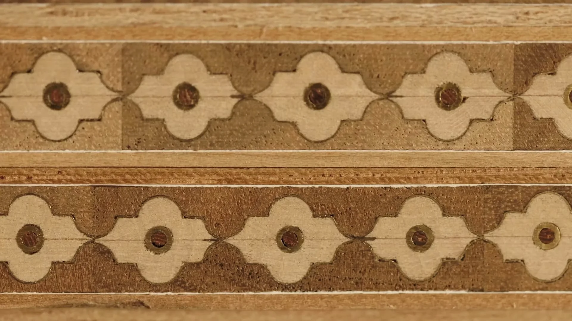 Close-up of intricate wood inlay design with geometric patterns.