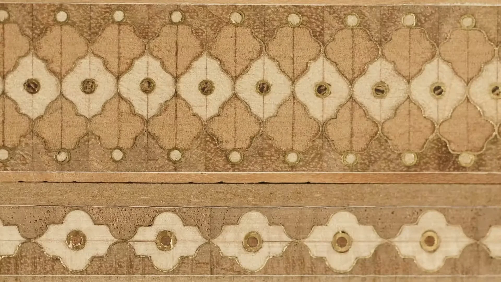 Close-up of a decorative wood carving with intricate geometric patterns and circular accents.