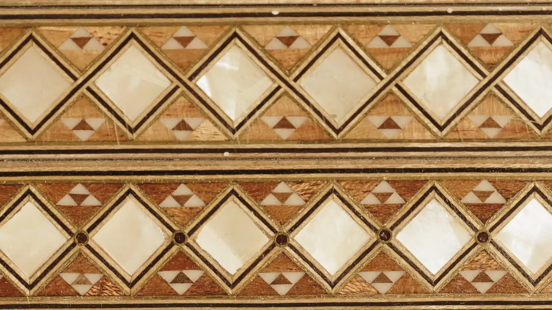 Inlaid geometric pattern with diamonds and triangles in wood and ivory tones
