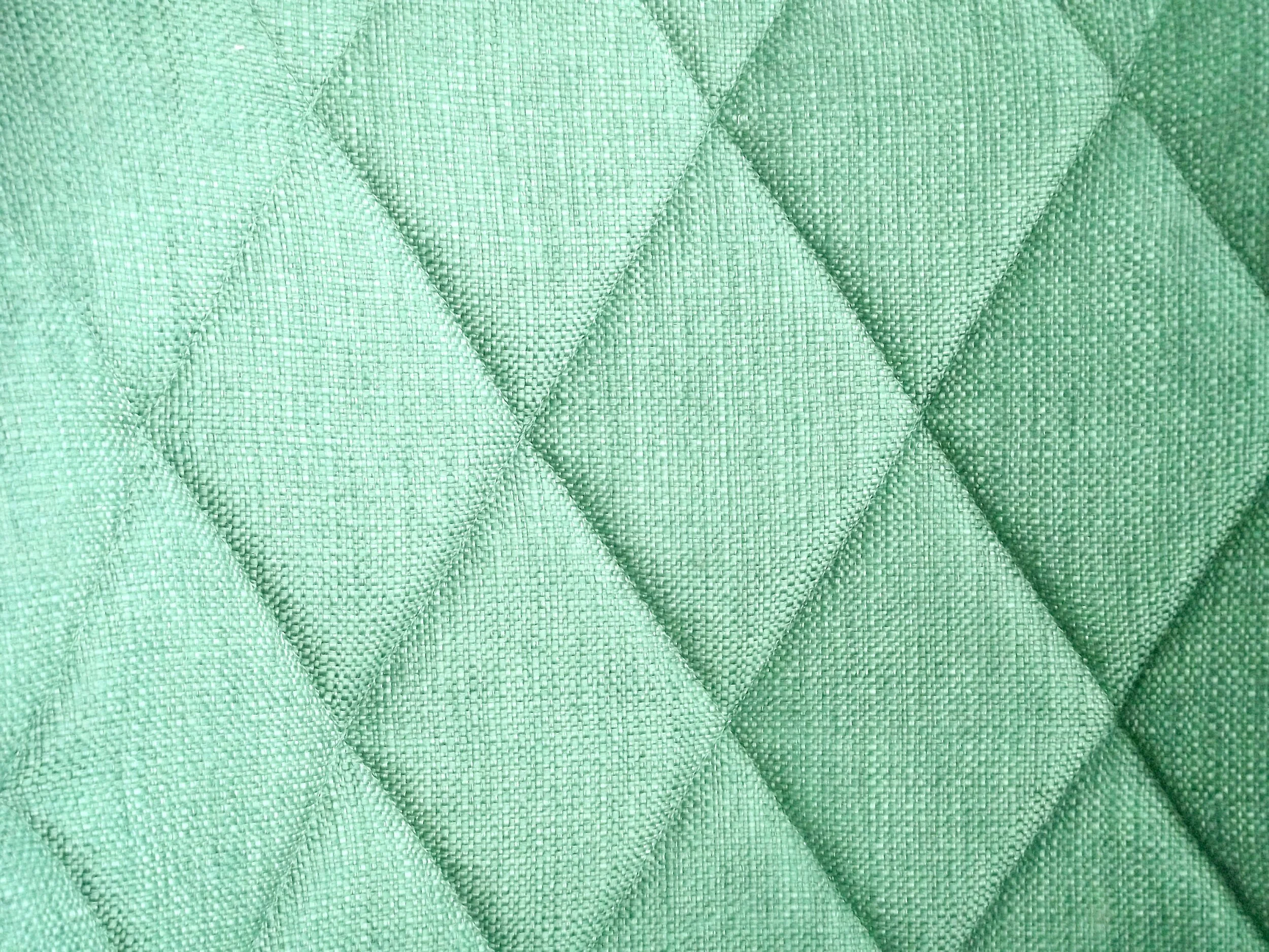 Green quilted fabric texture with diamond pattern