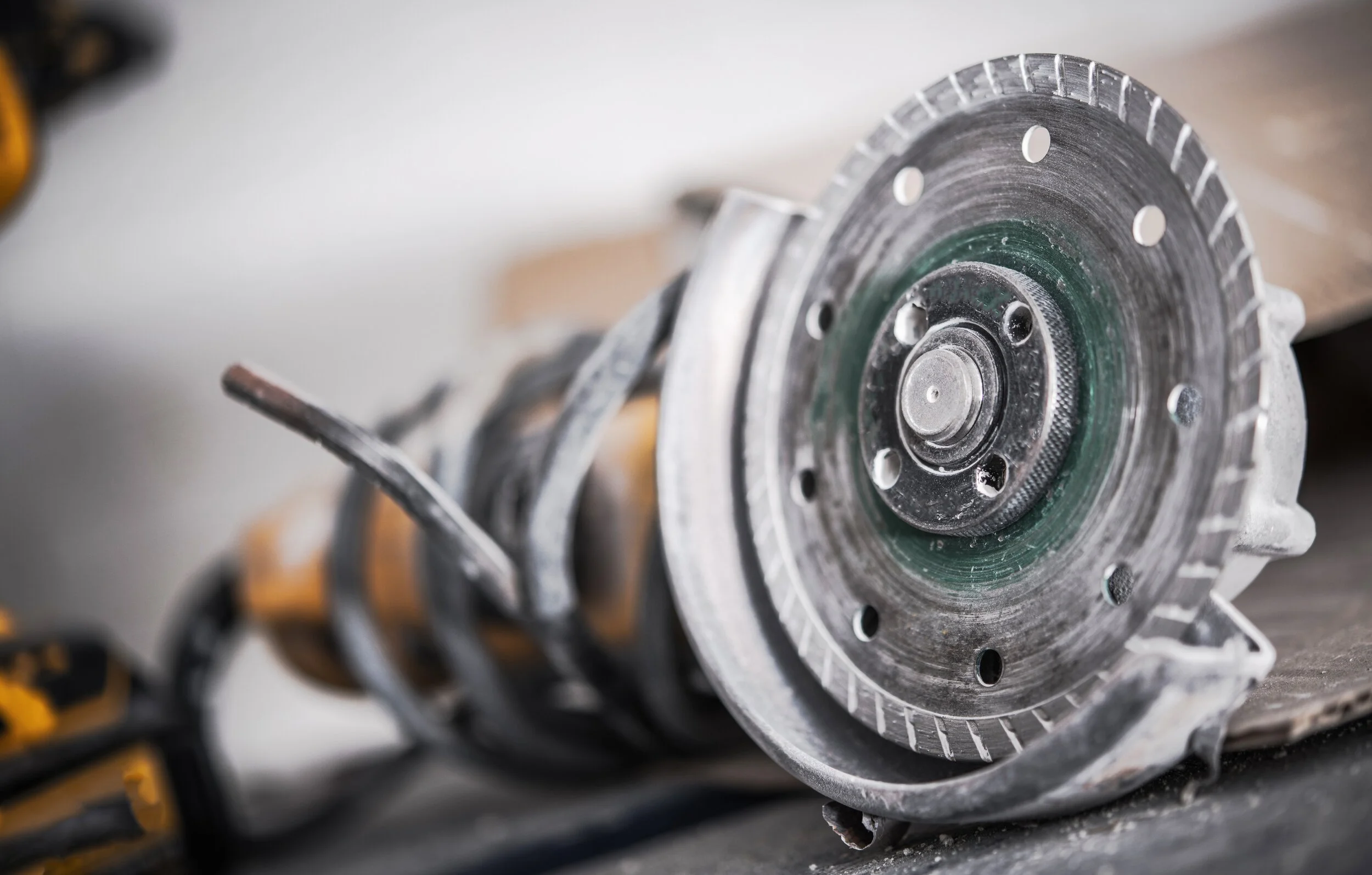 Close-up of an angle grinder with a circular cutting disc.