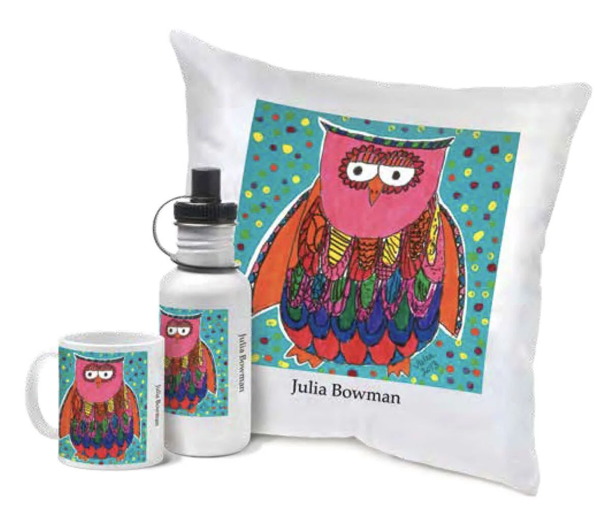 A white pillow, a white water bottle, and a white mug, all with a colorful owl illustration and the name 'Julia Bowman' on them. The owl has pink, orange, blue, green, yellow, and purple feathers, with a background of blue with multicolored dots.