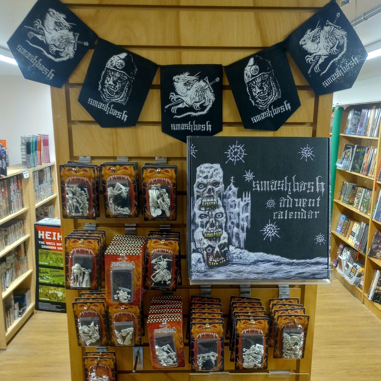 A display shelf in a store showing a black and white illustration of a skull with a cityscape on its forehead and the words 'sword of class' on a black banner featuring a dragon and a lion, along with various toy figures in packaging with similar art