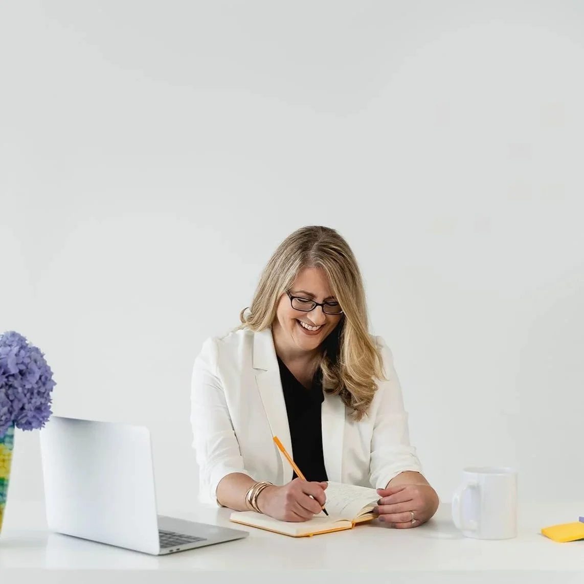 Karen Eber smiling and writing in a notebook