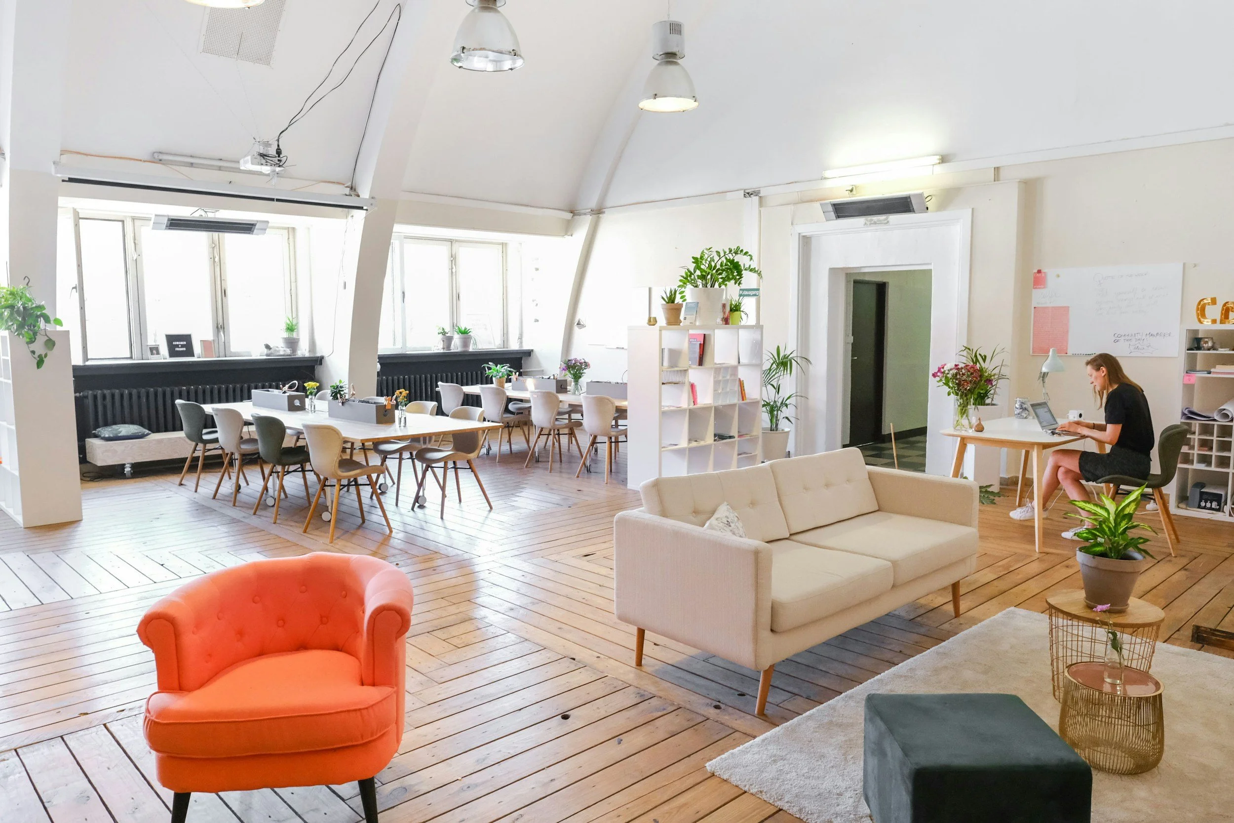 Stock image of a coworking space with chairs, desks and a sofa, all in creams and whites.