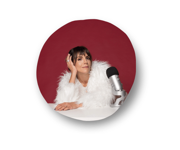 Marisa Corcoran, copy mentor and creator of The Copy Chat, wearing a white fur coat with her left hand resting on her head, next to a silver microphone.