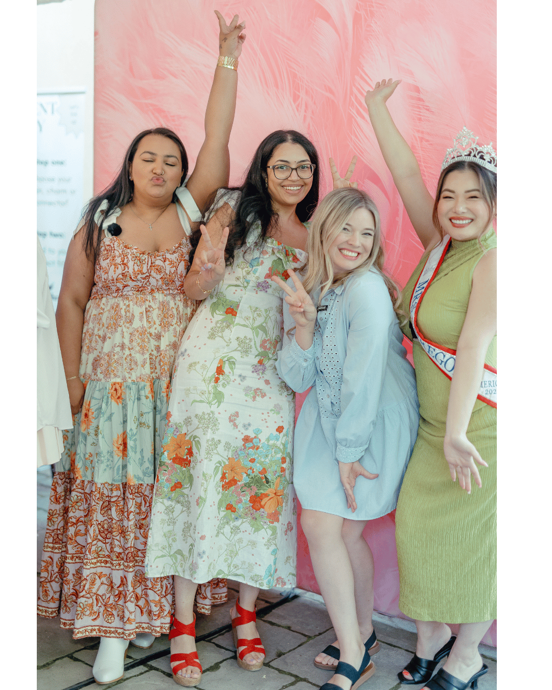 Isabelle Sarley with Alisha Kumar, Danielle Wiebe, and Mrs. Oregan America, Ellen Yin at Seattle Business Babes summer event, posing with arms up and giving peace signs against a pink background.