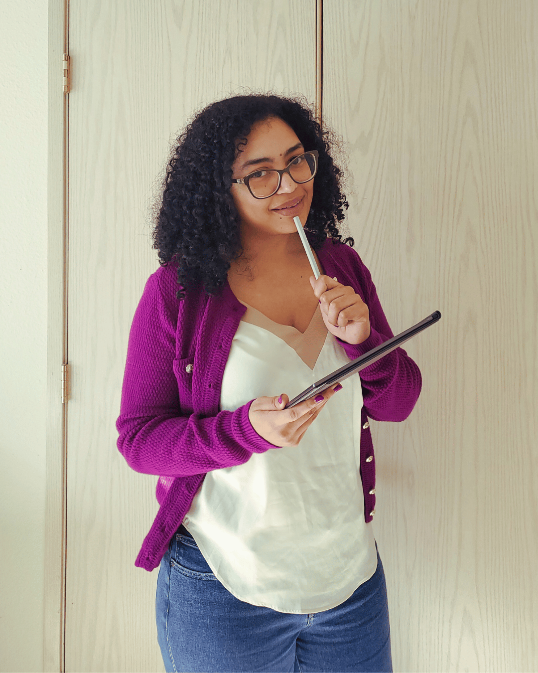 Isabelle Sarley, Email Marketer and Copywriter, smiling and holding a digital reMarkable notebook and holding a digital pen to her chin.
