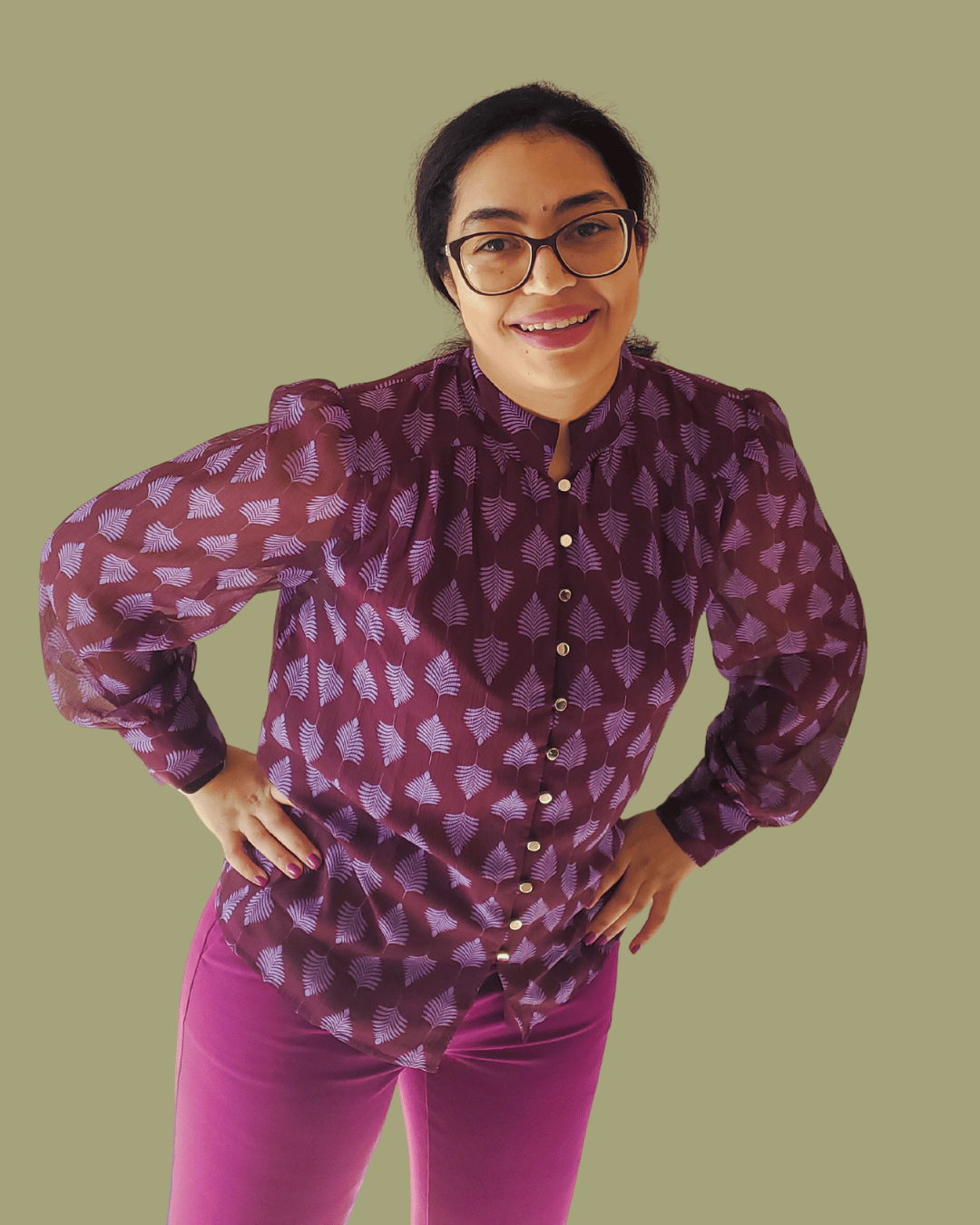 Isabelle Sarley, Email Marketer and Copywriter, smiling and wearing a purple blouse and suit pants, leaning towards the camera with her hands on her hips.