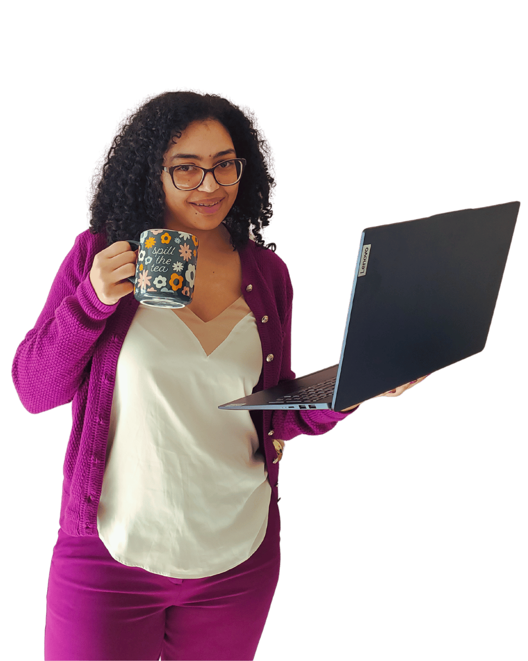 Isabelle smiling and holding a "spill the tea" mug with colorful flowers and an open navy blue laptop, wearing a vibrant purple cardigan, cream cami, and vibrant purple suit pants.