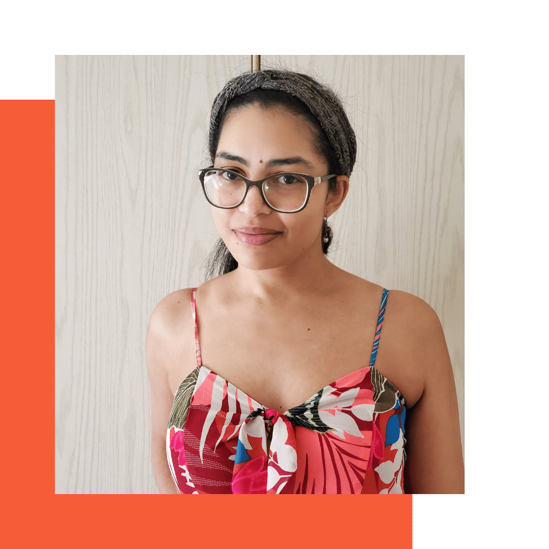 Close-up of Isabelle wearing a grey headband and a multi-colored dress with pink, red, white, blue, and a hint of earthy green.