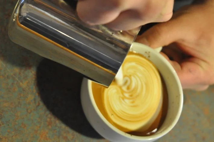 me pouring latte art before I was a roaster