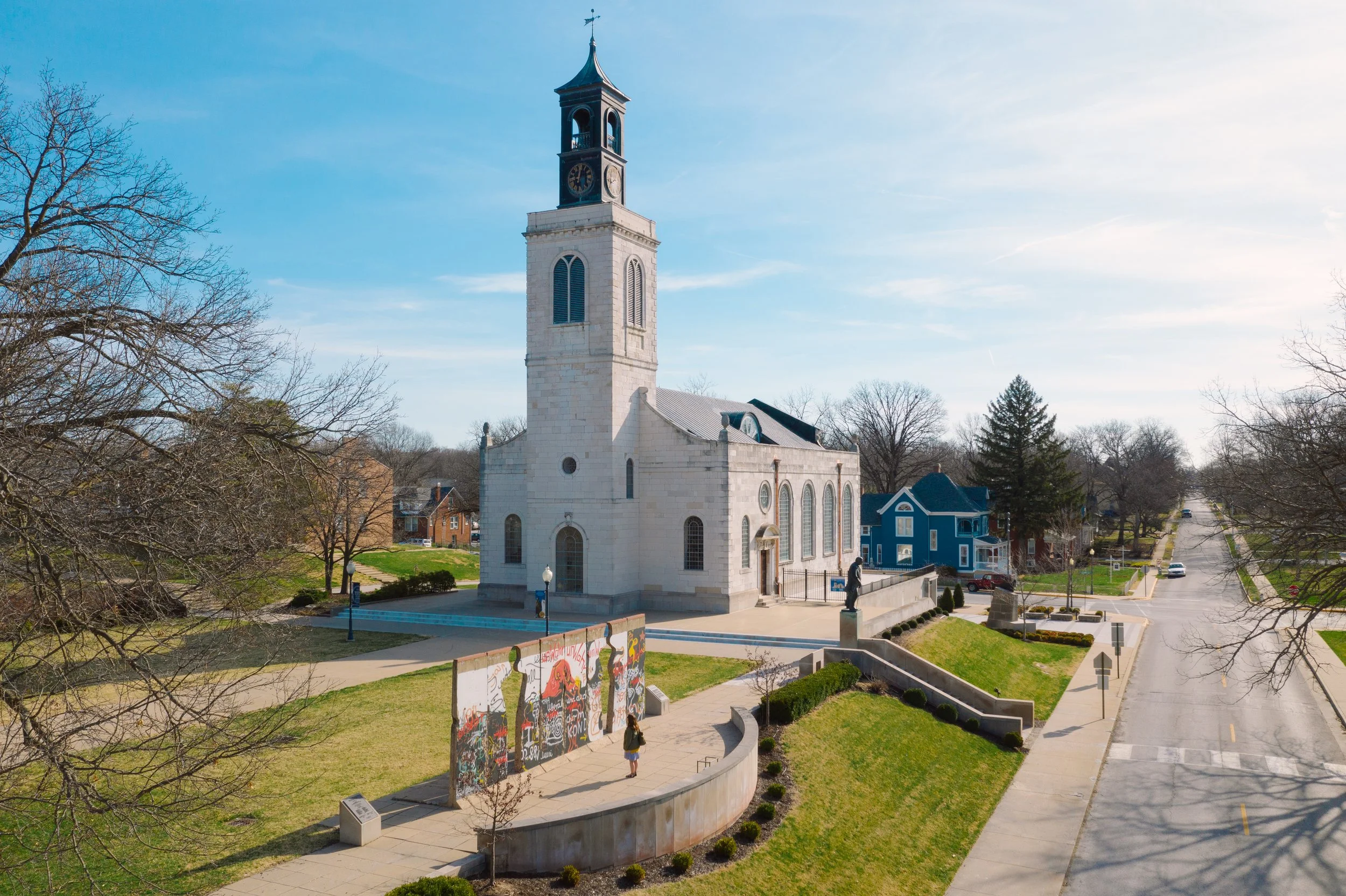 A wide shot of America's National Churchill Museum. The shot includes the Breakthrough Sculpture and the Church of St. Mary the Virgin, Aldermanbury.