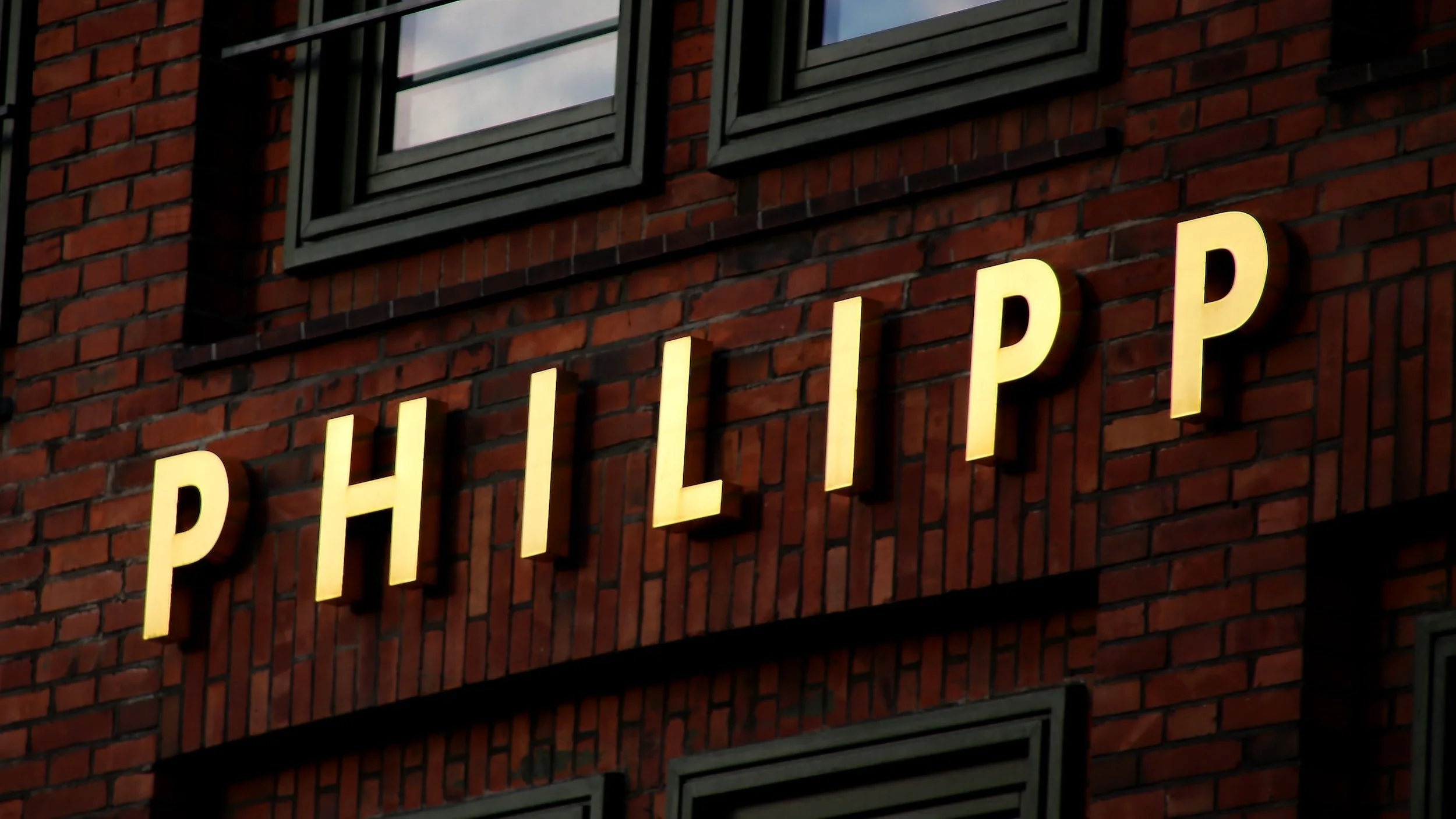 The name "PHILIPP" in uppercase golden letters on a brick wall.