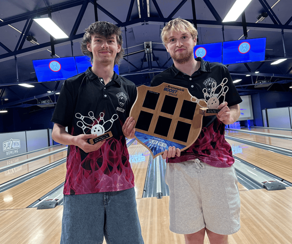 Two men holding the Play2Win Bowling competition shield, standing in the bowling alley at Play2Win Whanganui