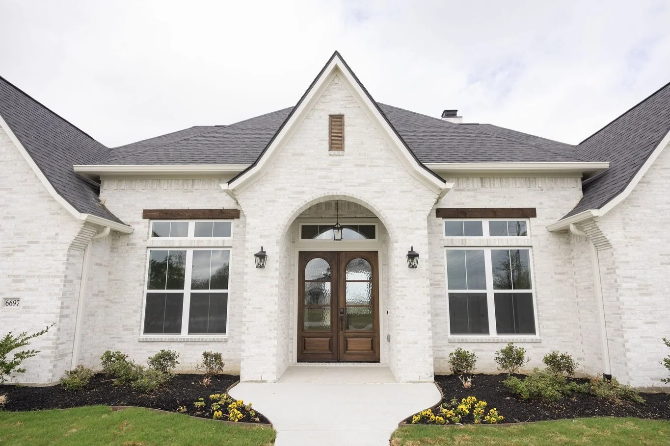 There&rsquo;s something special about walking up to a front door that instantly feels like home. 🏡

From the soft white brick to the warm wood doors and charming arched entry, this exterior creates the perfect first impression. It&rsquo;s timeless, 