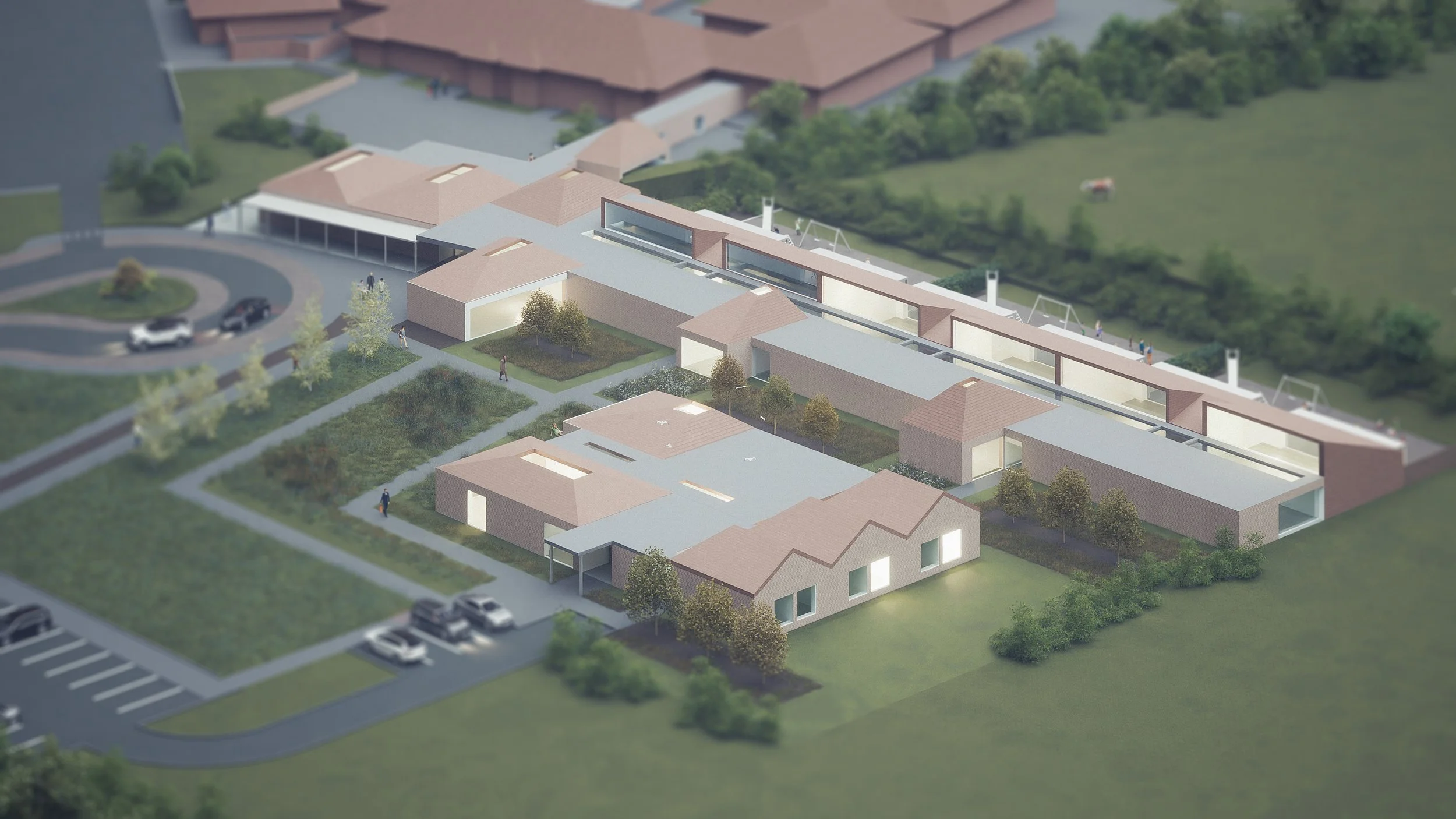 Aerial view of a modern residential or institutional building complex with landscaped gardens, parking lots, and surrounding greenery.