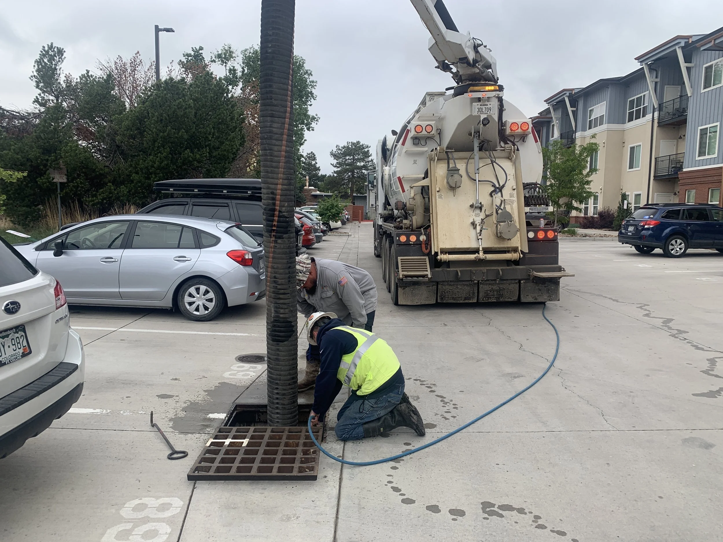 Affordable (Sustainable) Runoff Solutions crew vacuum-cleaning an underground catch basin and storm drain at a Colorado Front Range commercial property