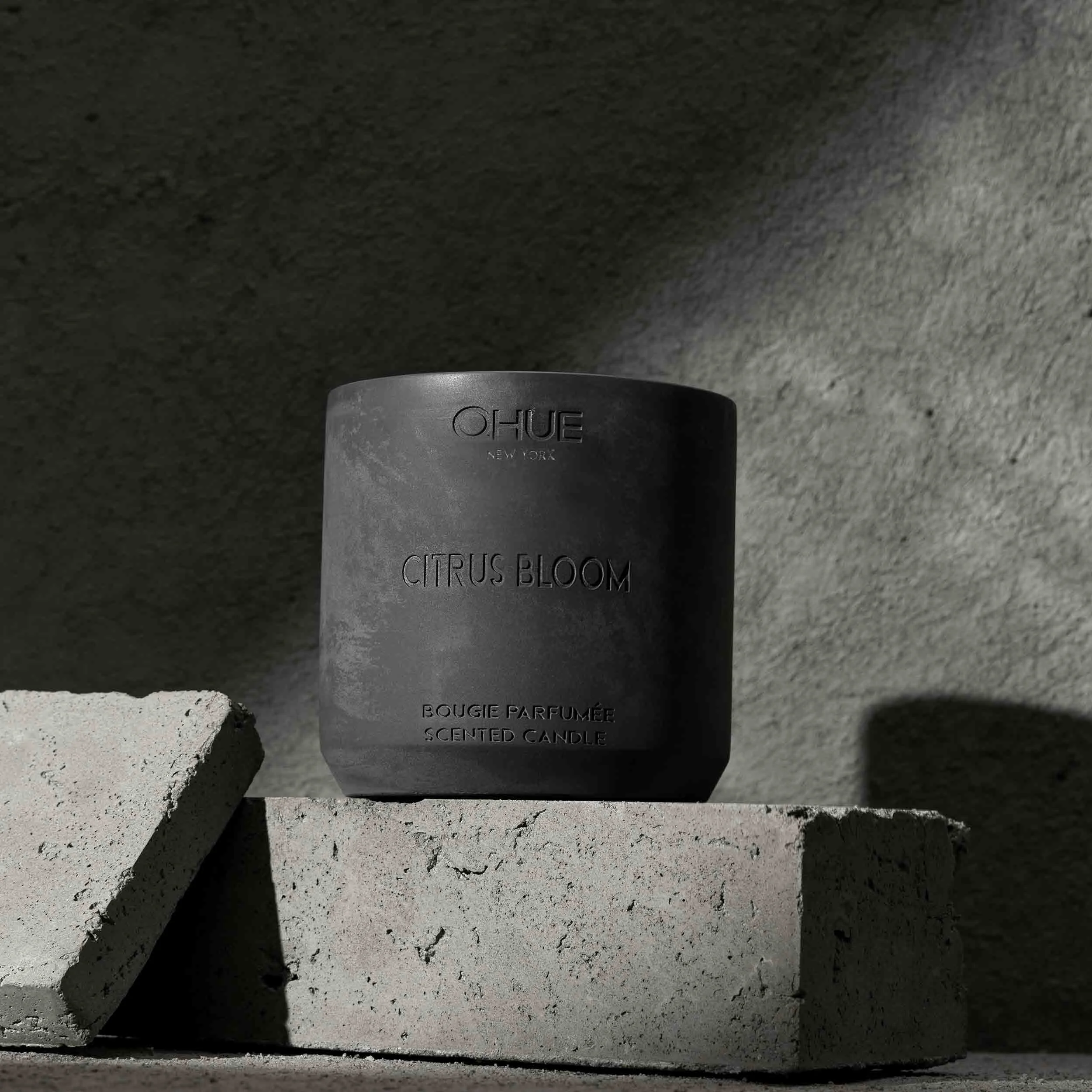 Qhue New York Citrus Bloom luxury scented candle in a handcrafted cement vessel.