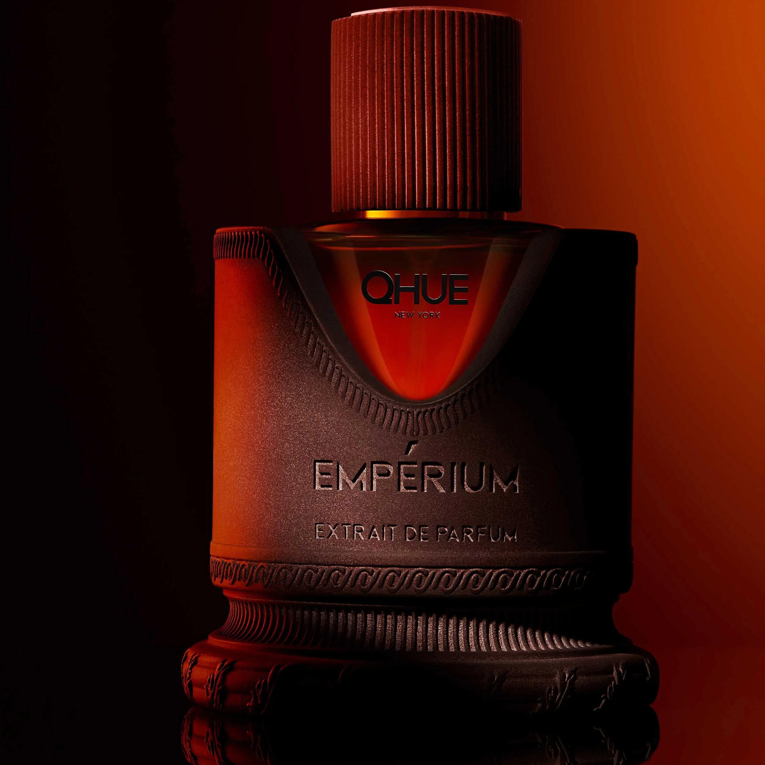 Qhue New York Emperium Extrait de Parfum luxury fragrance with dramatic red lighting on a dark background.