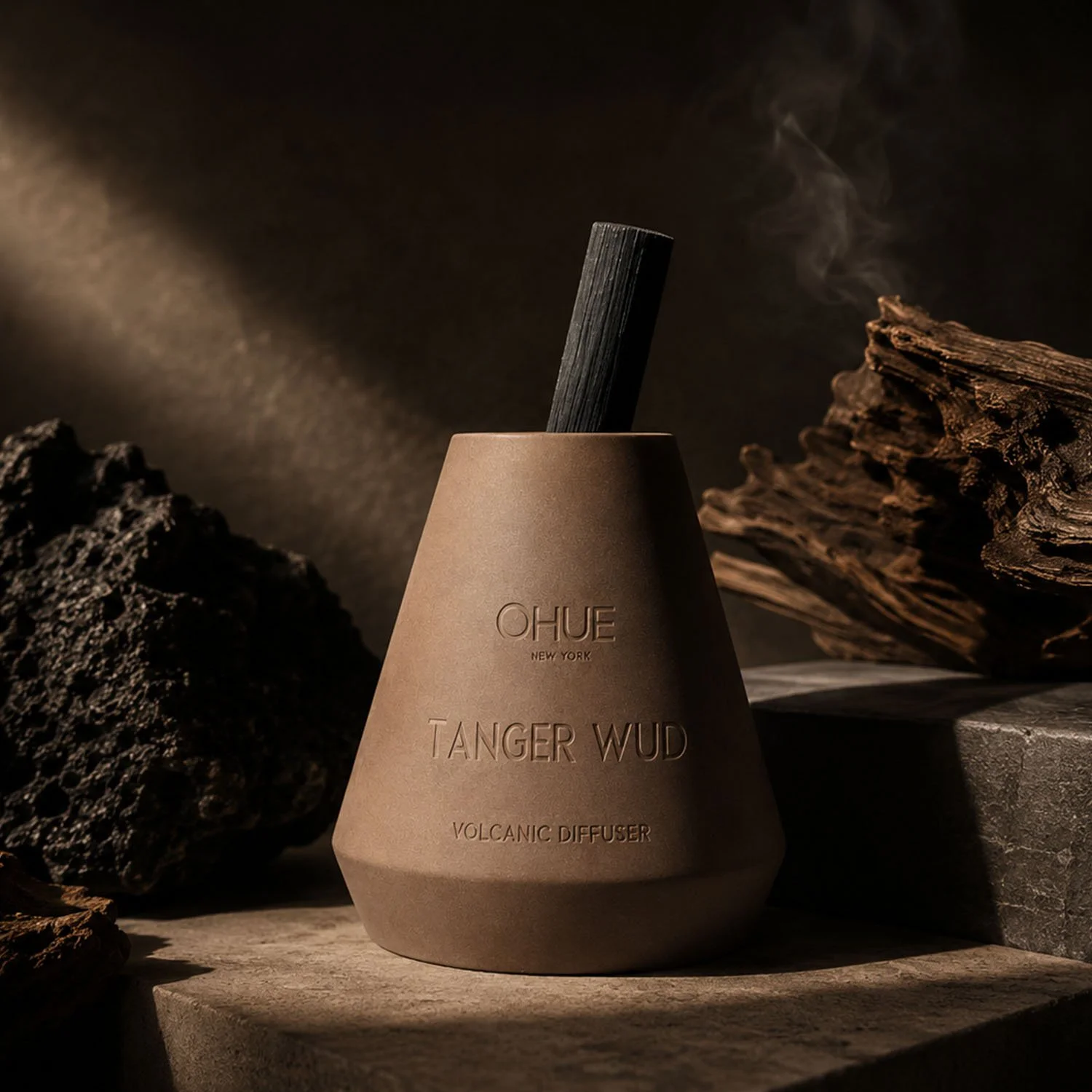 Qhue New York Tanger Wud Volcanic Diffuser in a warm, moody setting with volcanic stone, aged wood, and rising aromatic smoke.