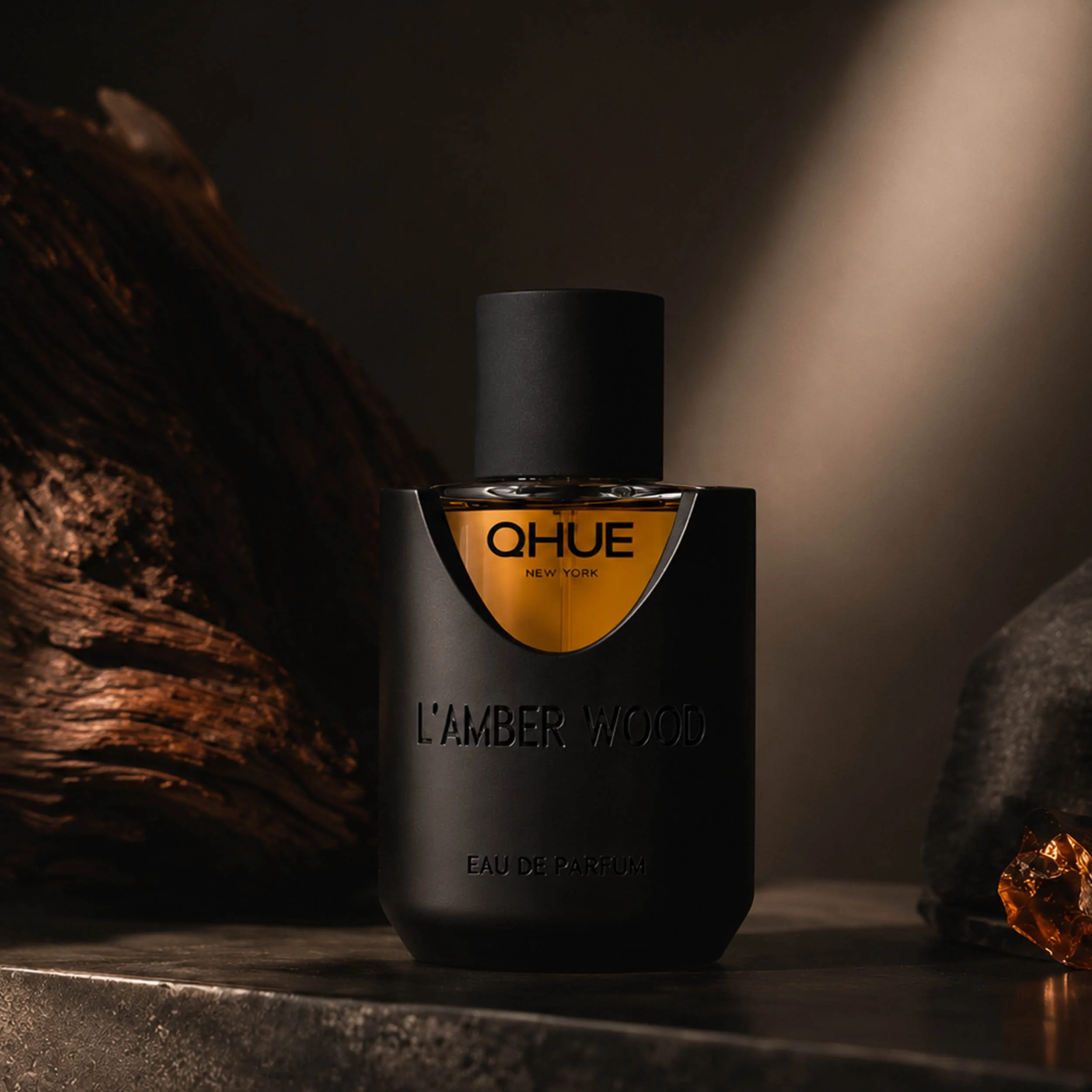 Qhue New York L’Amber Wood Eau de Parfum with warm amber wood styling.