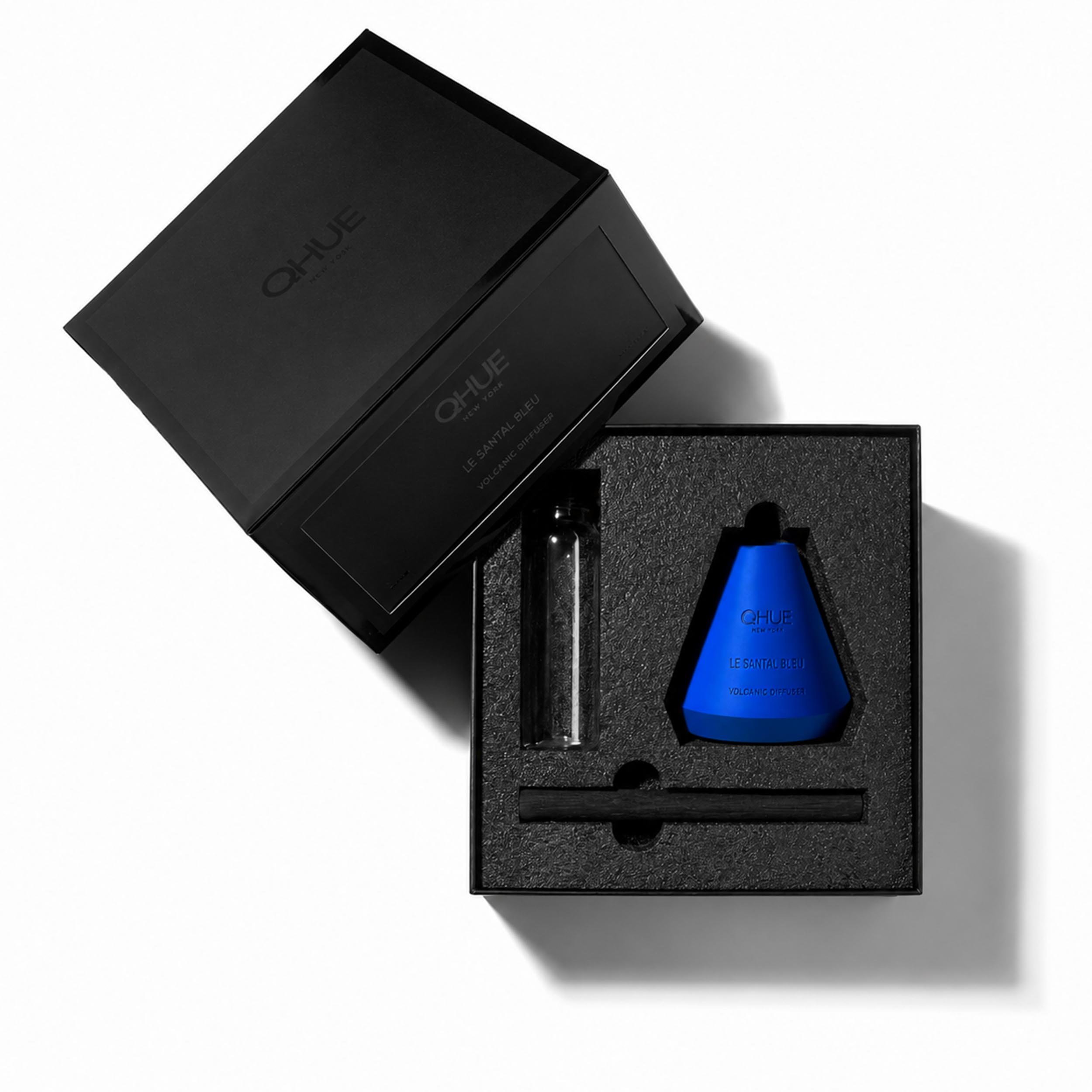 Qhue New York Le Santal Bleu Volcanic Reed Diffuser gift set with blue diffuser vessel, bamboo reed, refill bottle, and luxury black presentation box.