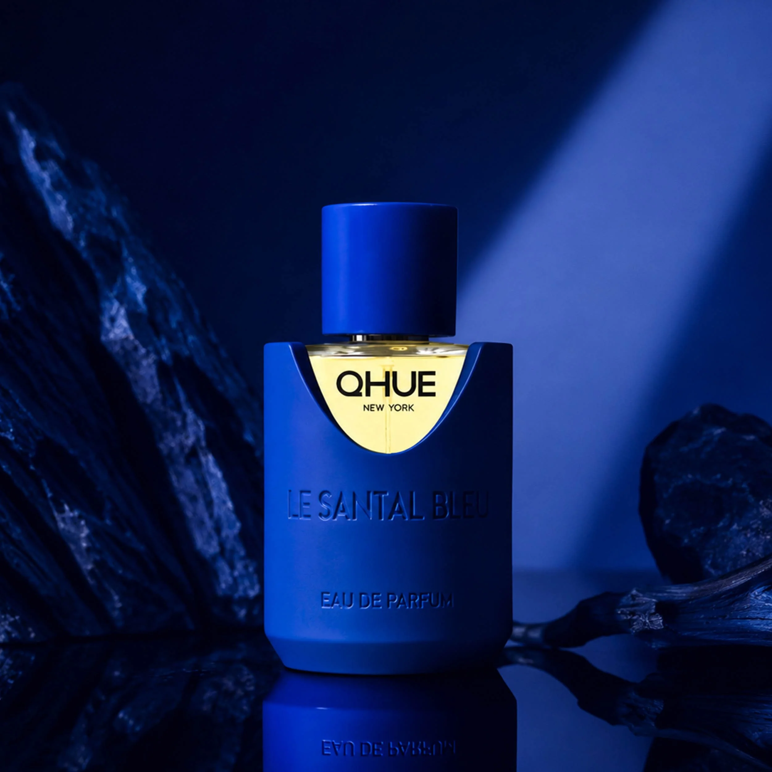 Qhue New York Le Santal Bleu Eau de Parfum showcased against a deep blue, mineral-inspired background.