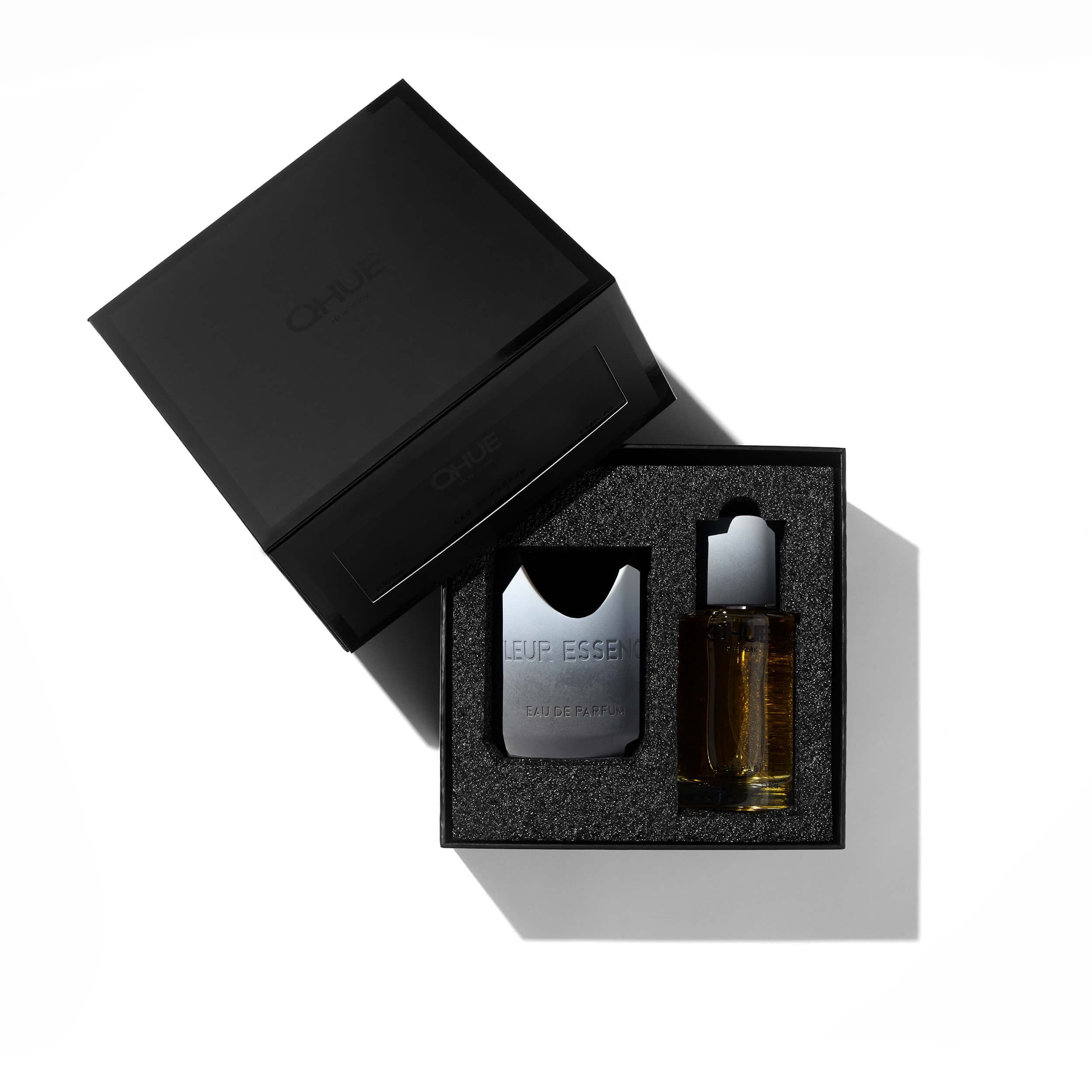 Matte black Qhue New York gift box containing Fleur Essence Eau de Parfum and refill vial arranged in black foam.