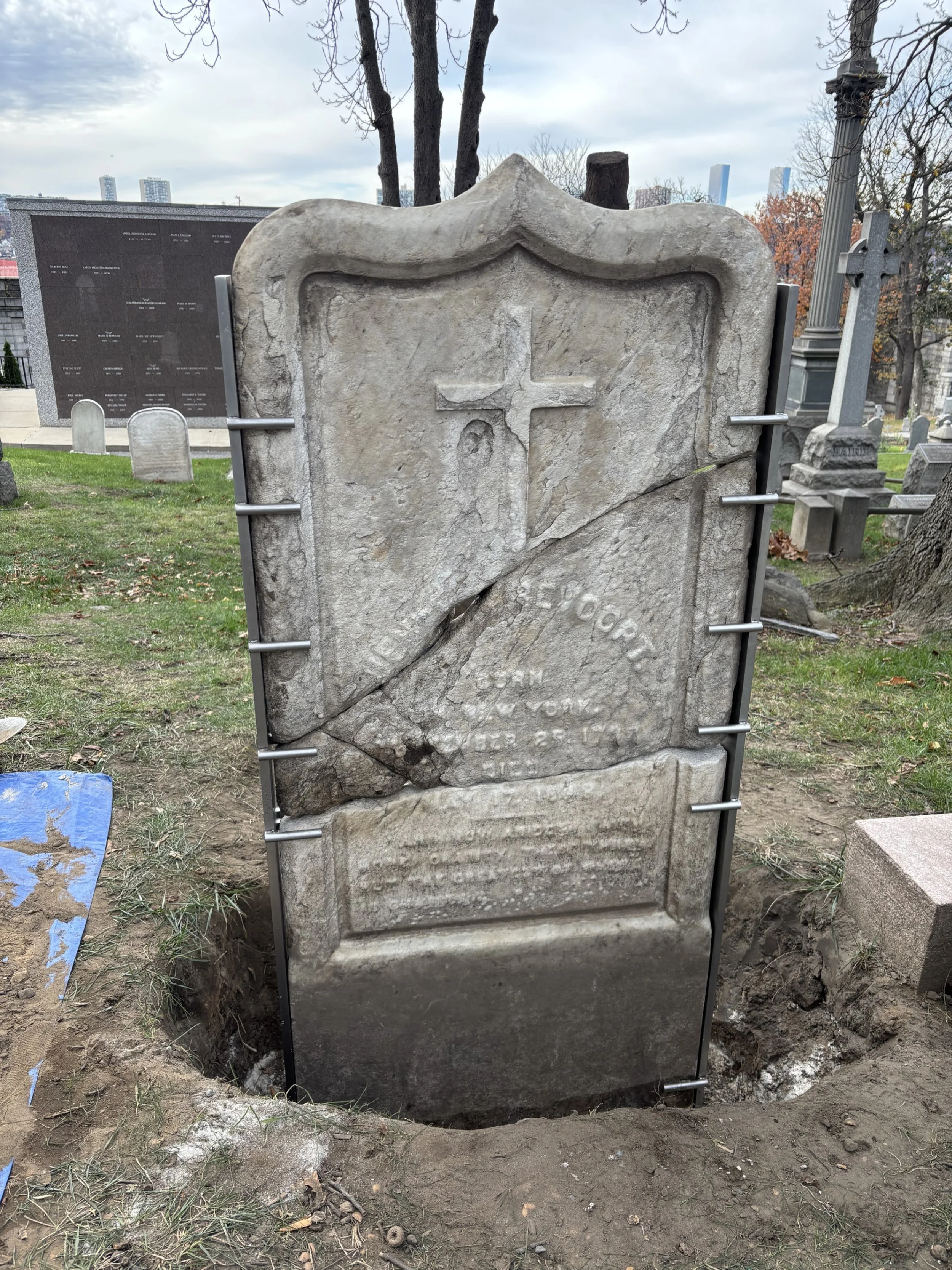 A custom stainless steel armature supports a repaired marble cemetery marker.