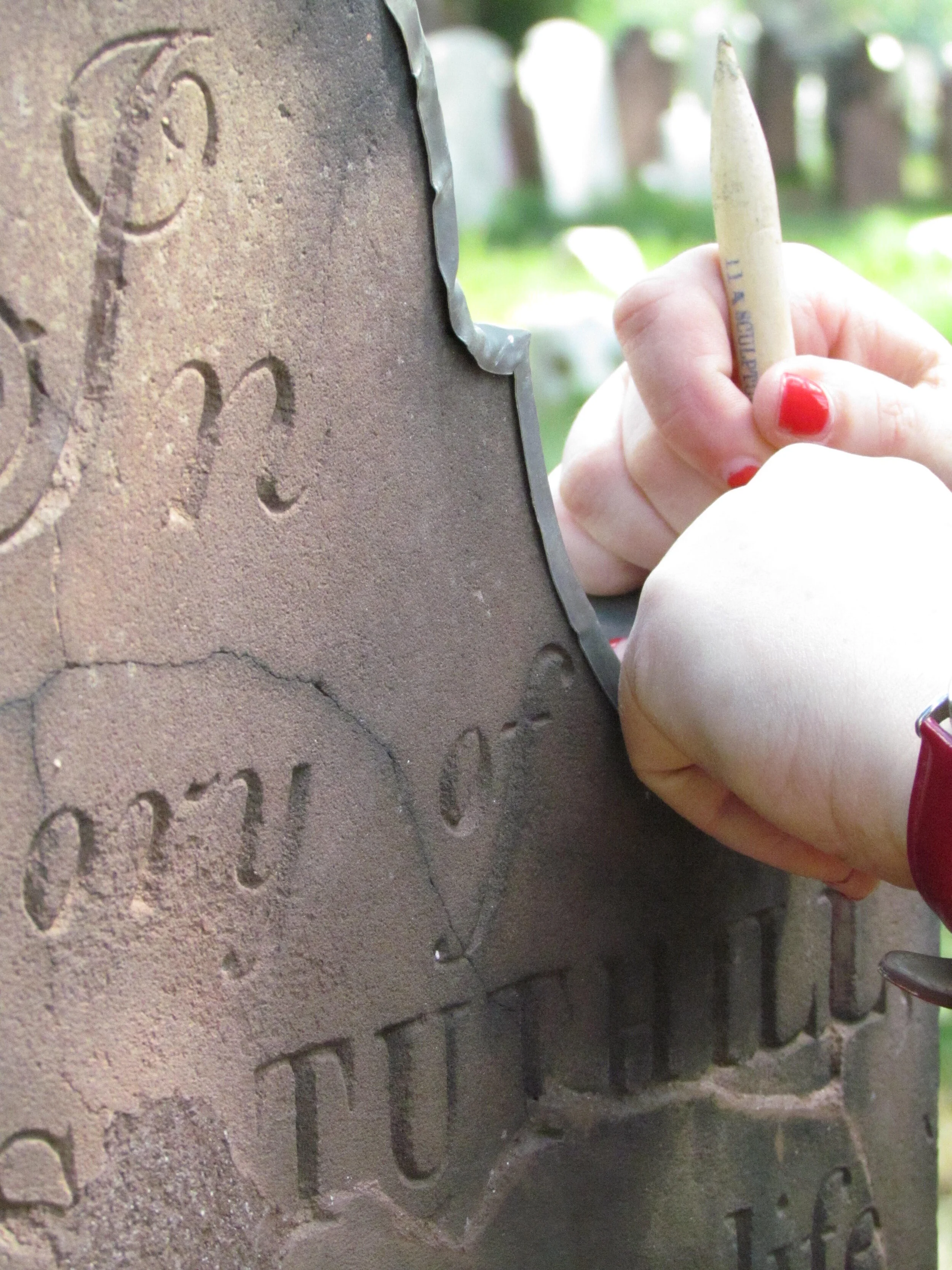 Fitting a lead cap to protect a delaminating cemetery marker.